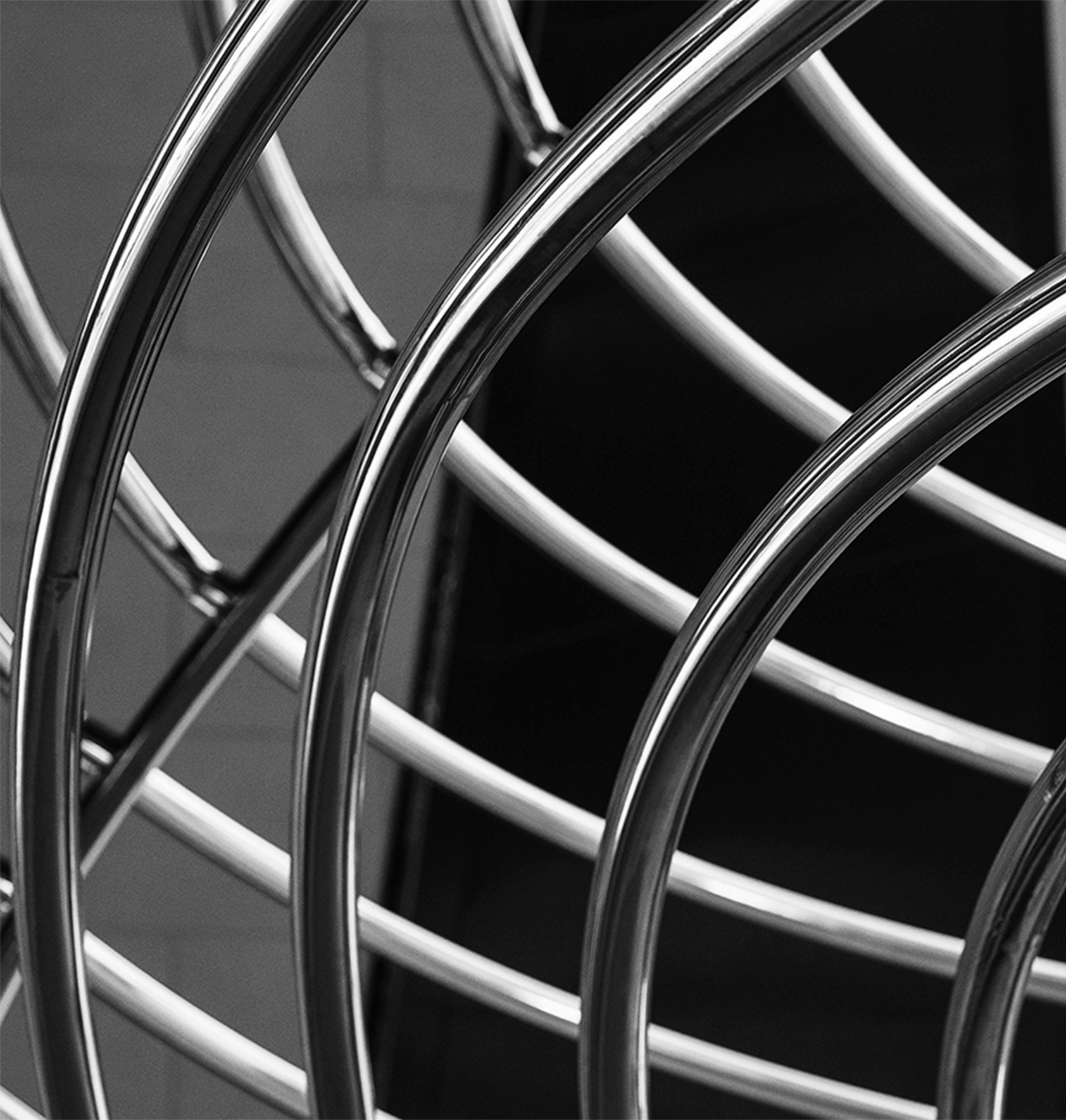 Estrutura tubular cromada em espiral, fotografada em preto e branco